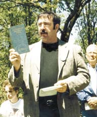 Clyde Croasdale reads from a book of poetry to honor his father at Saturday's rededication